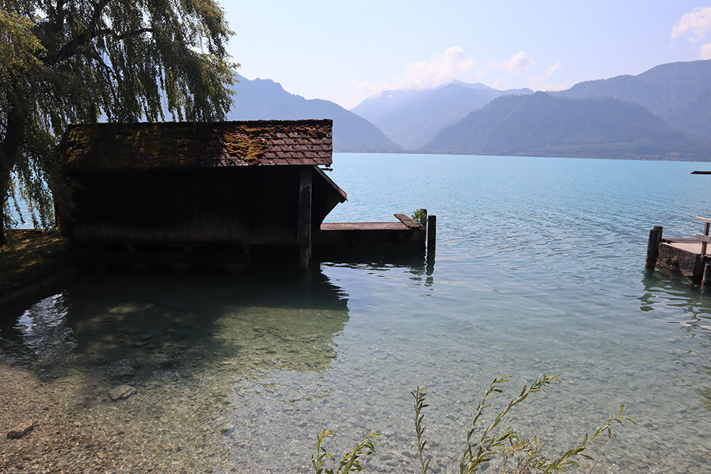 See mit Booten und Bergen im Hintergrund